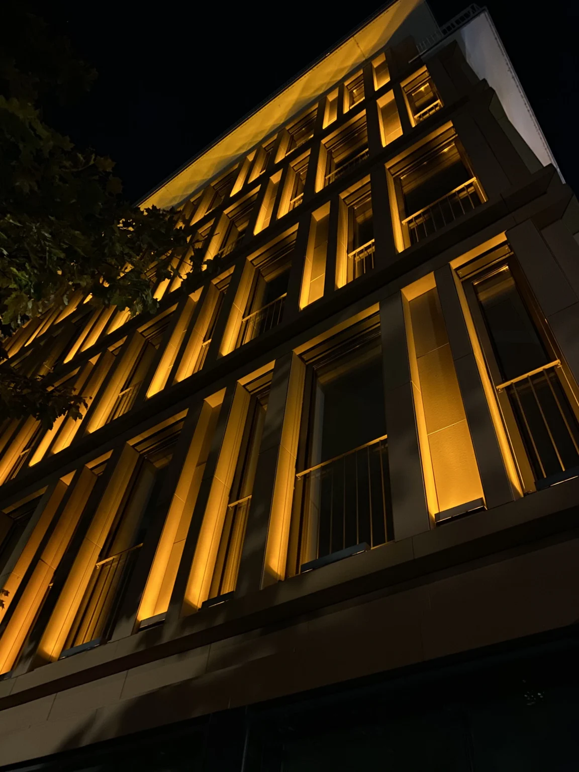 Warm verlichte gevel van een bedrijfspand in de avond